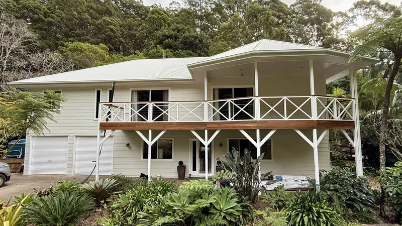Painted Queenslander home surrounded by trees on the Sunshine Coast