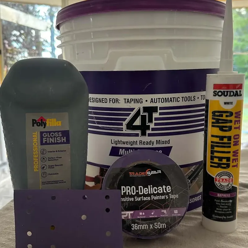 Prep products lined up: fillers, gap filler, painter's tape and a sanding pad