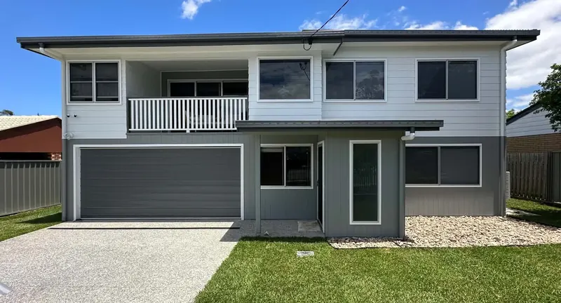 Two-storey home painted in white weatherboard with a grey lower level